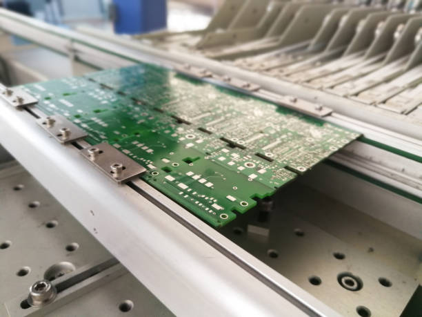 istock PCB assembly first stages. PCB on the rails of production line inside pick and place machine 957582918