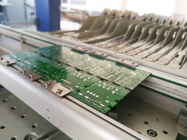 istock PCB assembly first stages. PCB on the rails of production line inside pick and place machine 957582922