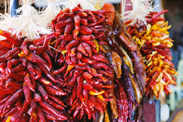 istock Red Dried peppers hanging at public market 957583928