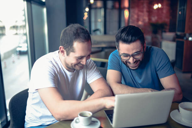 istock Handsome Smiling Freelancer Showing Finished Project on Laptop to a Colleague 957587768