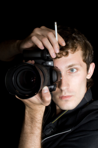 Studio photo of an adult handsome young man with the old retro camera