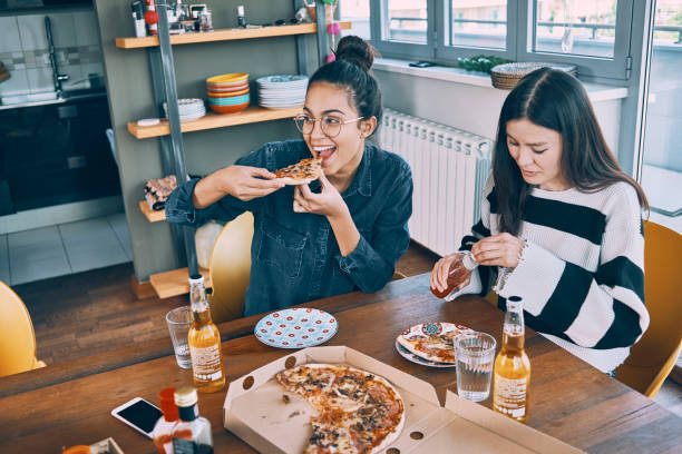 istock two friends having pizza for lunch 957591314