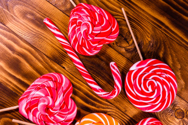istock Different sweet lollipops on a wooden table. Top view 957597052