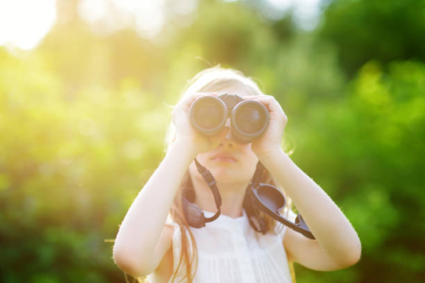 istock Funny little girl looking through binoculars 957598242