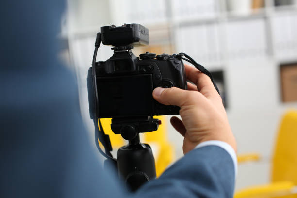istock Male arms in suit mount camcorder to tripod 957604844