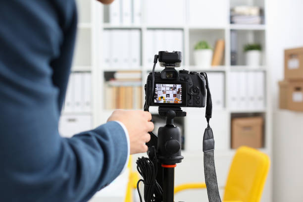 Male arms in suit mount camcorder to tripod