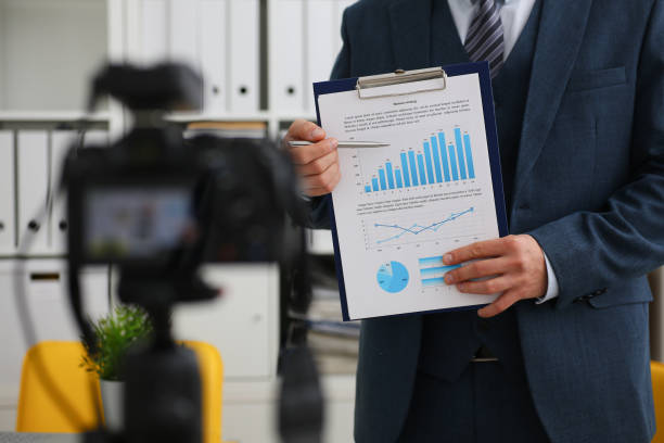 istock Male in suit and tie show stats graph pad 957604874