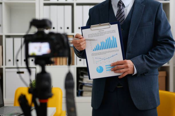 istock Male in suit and tie show stats graph pad 957604876
