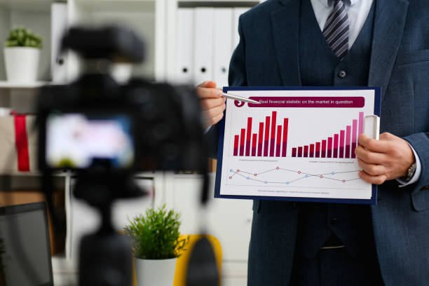istock Male in suit and tie show stats graph pad 957604890