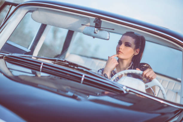 istock Attractive Retro Style Woman in Old Timer Car at Sunset 957605346