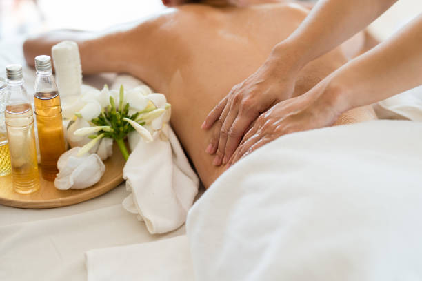 jonge mooie aziatische vrouw slapen ontspannen in de spa massage van de olie in de salon. selecteer focus hand van masseuse - massage stockfoto's en -beelden