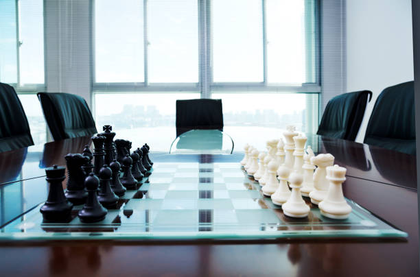 istock Chess pieces and board on the conference table 957612500