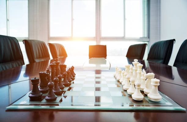 istock Chess pieces and board on the conference table 957612510