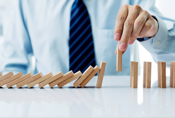 istock Businessman hand pick up one domino 957613060
