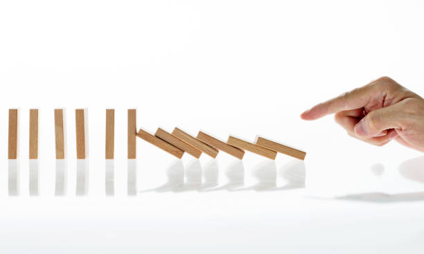 istock Man hand pushing domino pieces 957613090