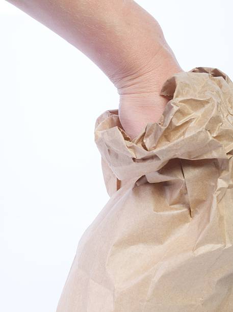 hand reaching into paper bag stock photo