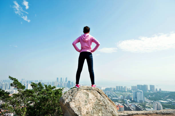 istock Woman standing on the mountain peak rock 957616760