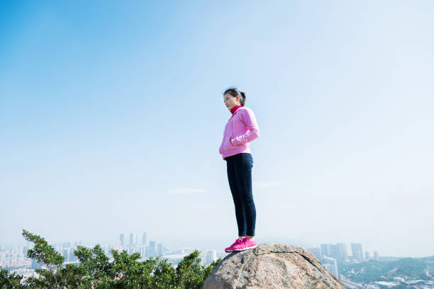 istock Woman standing on the mountain peak rock 957616786