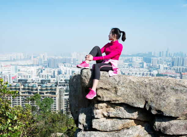 istock Woman sitting on mountain top enjoy the view 957616842