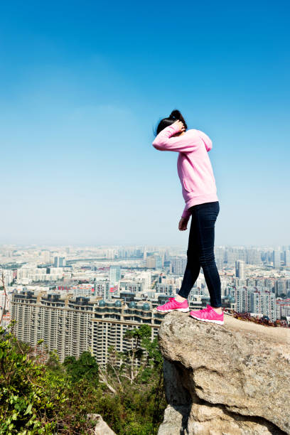 istock The desperate woman standing on the mountain peak 957617272