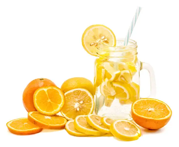 Photo of lemonade in a mason jar with a drinking straw decorated with slices of lemon and orange isolated on white background