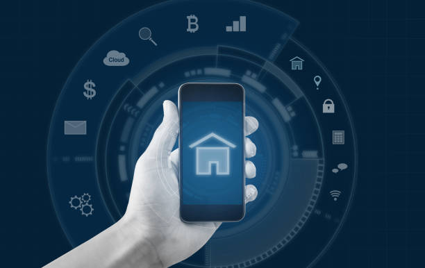istock Smart home and buildings mobile application. Hand holding mobile smart phone 957621138