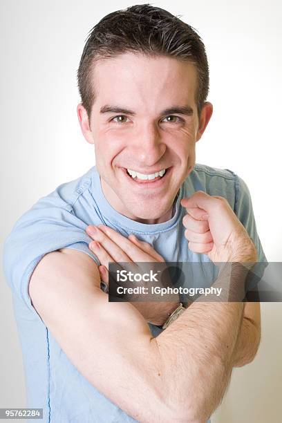 Foto de Feliz Jovem Mostrando Seu Bíceps E Smilling e mais fotos de stock de Adulto - Adulto, Autoconfiança, Azul