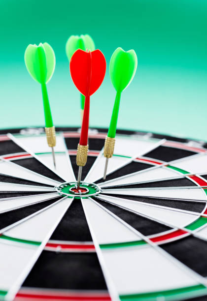 istock Dart board with arrows on green background 957624276