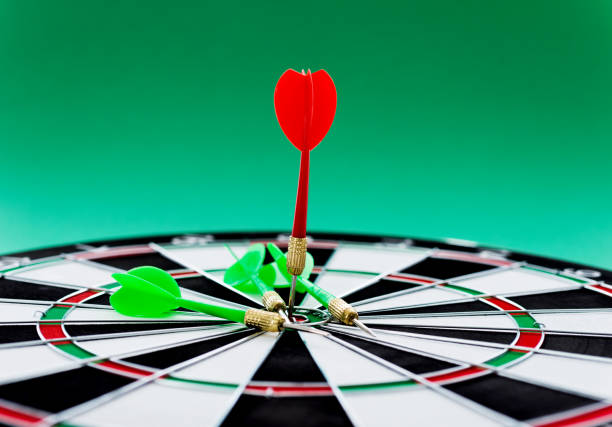 istock Red and green dart arrows on dartboard 957624332