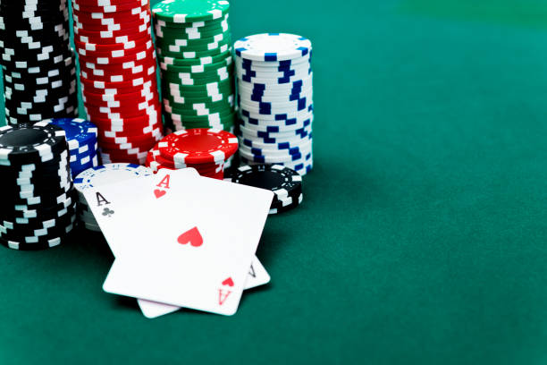 istock Aces and poker chips on card table 957629640