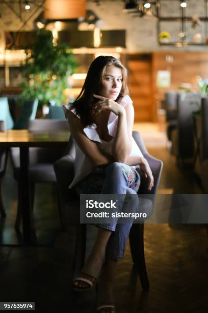 Stylish Woman Sitting At Cafe And Wearing White Blouse With Ethnic Jeans Stock Photo - Download Image Now