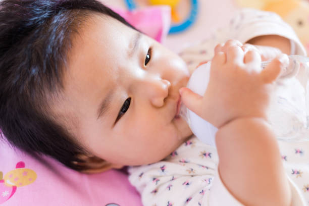 istock Baby drinking milk close-up 957638806