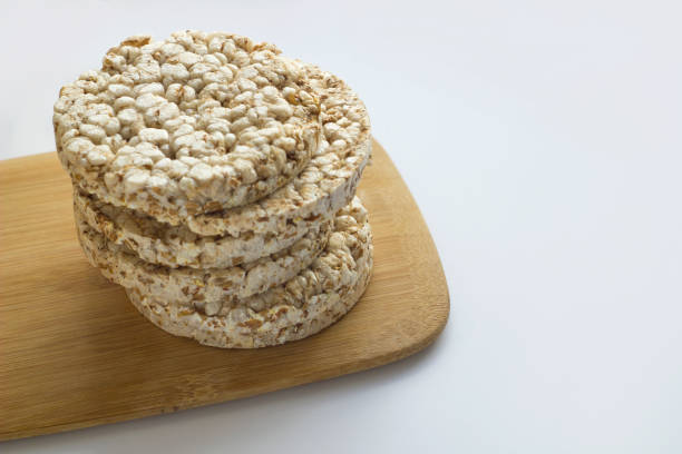 istock Stack of round rice crispbreads on wooden board. 957651124