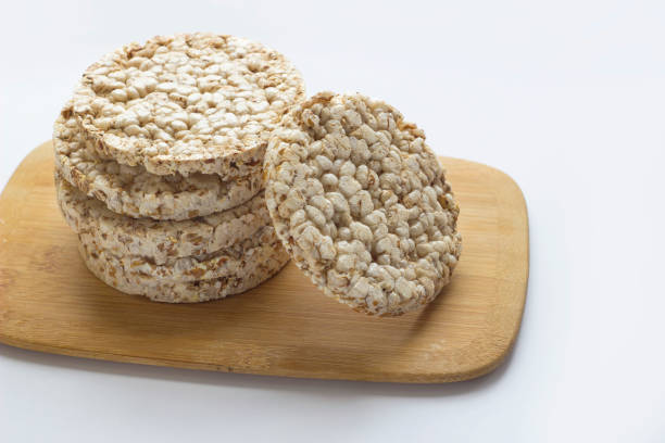 istock Stack of round rice crispbreads on wooden board. 957651150