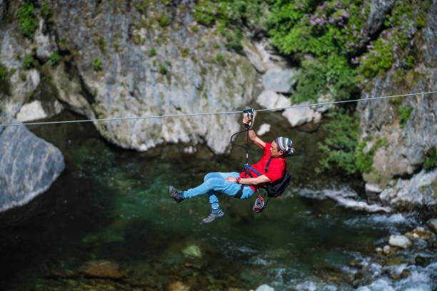 istock Man on a zip line flying through a forested canyon 957654418