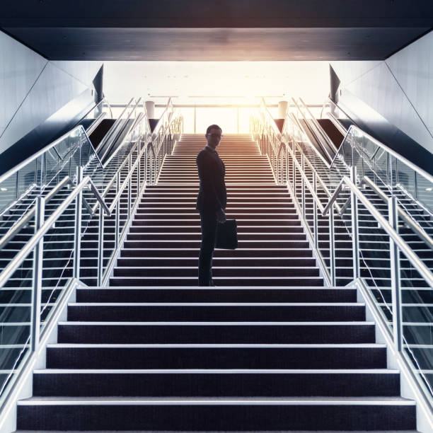 istock Businessman on staircase low angle view. 957655098