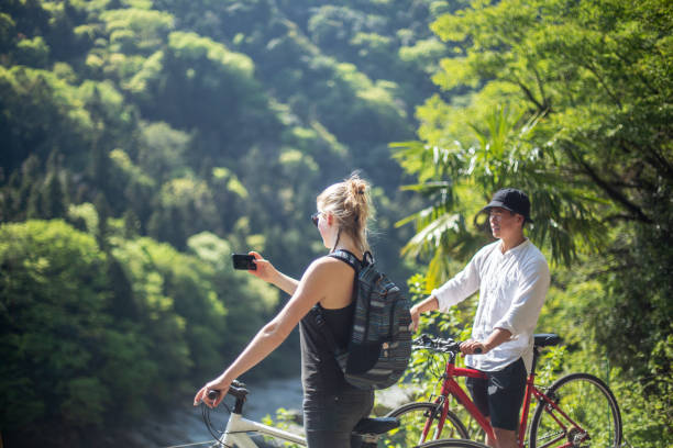 istock Young couple taking a photo while cycling in the mountains 957655340