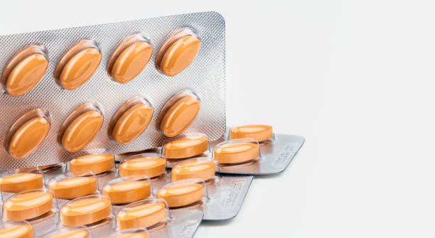 istock Orange oval tablet pills isolated on white background. Medicine for treating venous circulation disorders (swollen legs, pain, restless legs) and hemorrhoids and acute hemorrhoidal attack. 957655476