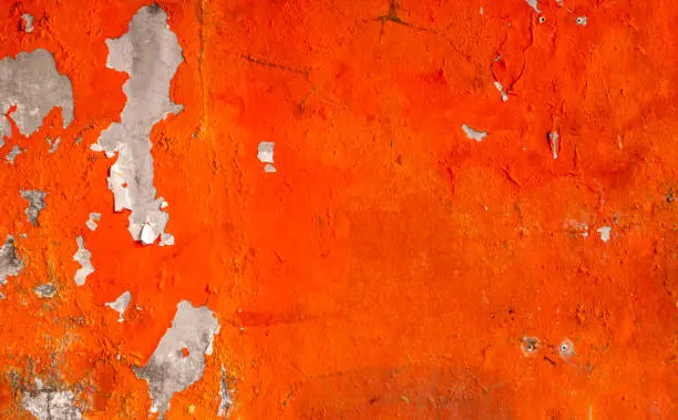 Photo of Orange color painted on concrete wall are peeling. Old and dirty wall texture background with space.