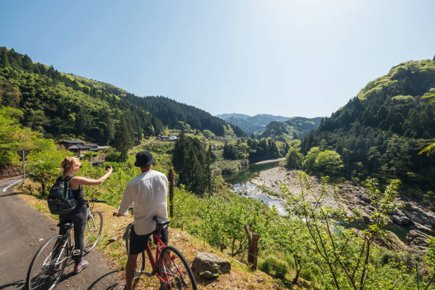 istock Young couple taking a photo while cycling in the mountains 957655776