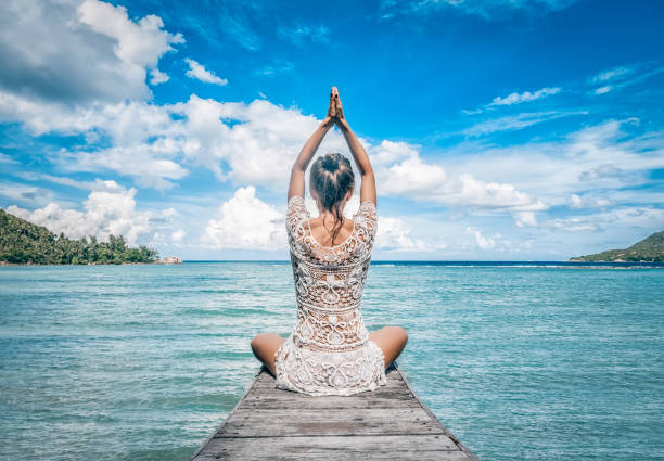 istock Young woman making meditation on the beach 957655832