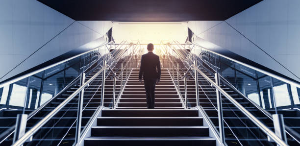 empresario en vista de ángulo bajo escalera. - escalator steps staircase moving up fotografías e imágenes de stock