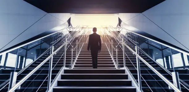 Photo of Businessman on staircase low angle view.