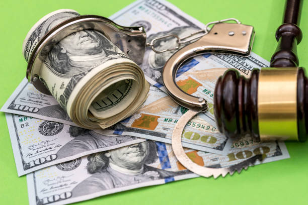istock Handcuffs, dollar notes and judge's gavel on green background 957665532