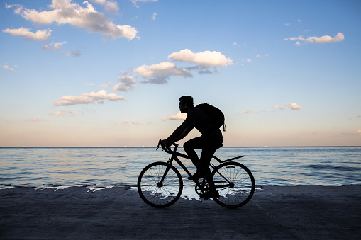 Young man cycling in Chicago by Michigan lake, commuting to work, United States.