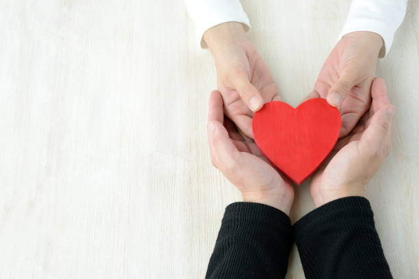 istock Heart had by man and woman's hand 957669558