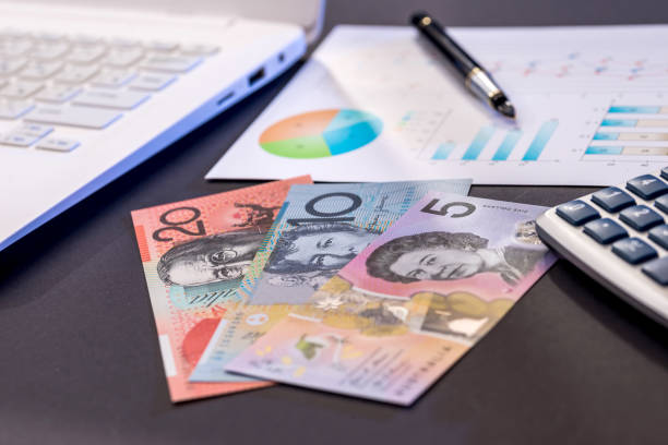 istock aud  dollar  laptop and diagram on black 957670064