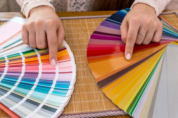 istock Female hands choosing colour on swatch, closeup 957670474