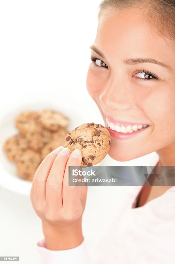 Mulher bonita comendo cookie quente com pedaços de chocolate - Foto de stock de Biscoito de Chocolate royalty-free