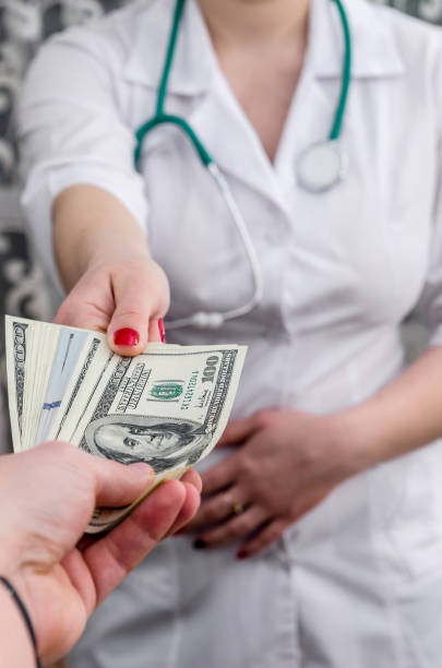 istock Bribery , hands of a doctor with dollars 957674242